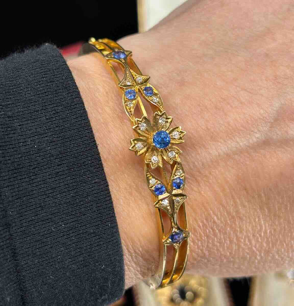 Australian antique bangle by Duggin Shappere & Co., 15ct yellow gold floral sapphire and diamond bracelet worn on wrist