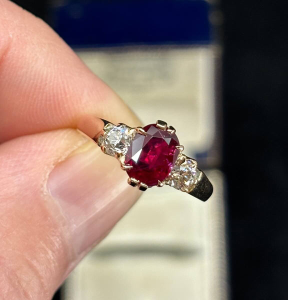 Side profile of 1905 Edwardian oval ruby and diamond ring showing claw settings, tapered 3.20–1.60mm band and antique old‑European diamond shoulders.