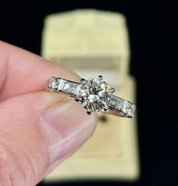 Vintage 1950s brilliant cut diamond engagement ring in 18ct white gold, 1.30ct center stone with baguette shoulder diamonds, top view in antique ring box.
