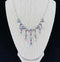 Front view of a vintage 1920s moonstone and ruby fringe necklace in sterling silver, showcasing Art Deco elegance.