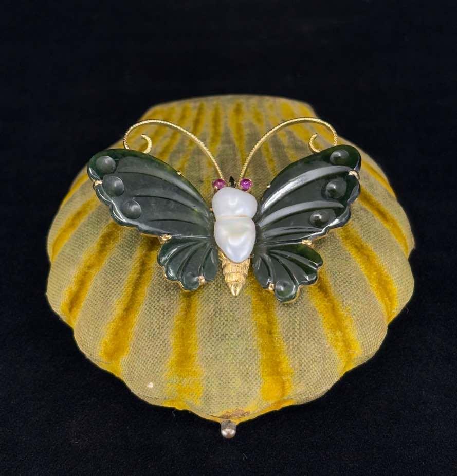 Vintage brooch image featuring nephrite wings, a baroque freshwater pearl, and ruby eyes in 14ct gold.