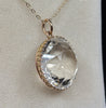 Angled view of the Victorian rock crystal pendant showing its high-domed faceted crystal and closed gold collet setting