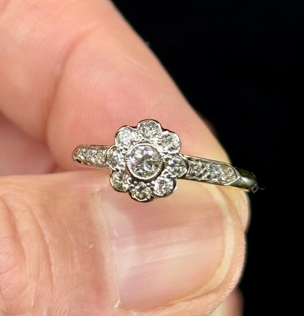 1920s Old European cut posy cluster ring in 18ct white on yellow gold showing nine Old European cut diamonds.