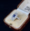 1930s antique Art Deco ring showcasing a deep blue sapphire and pavé-set old cut diamonds in a tonneau design.