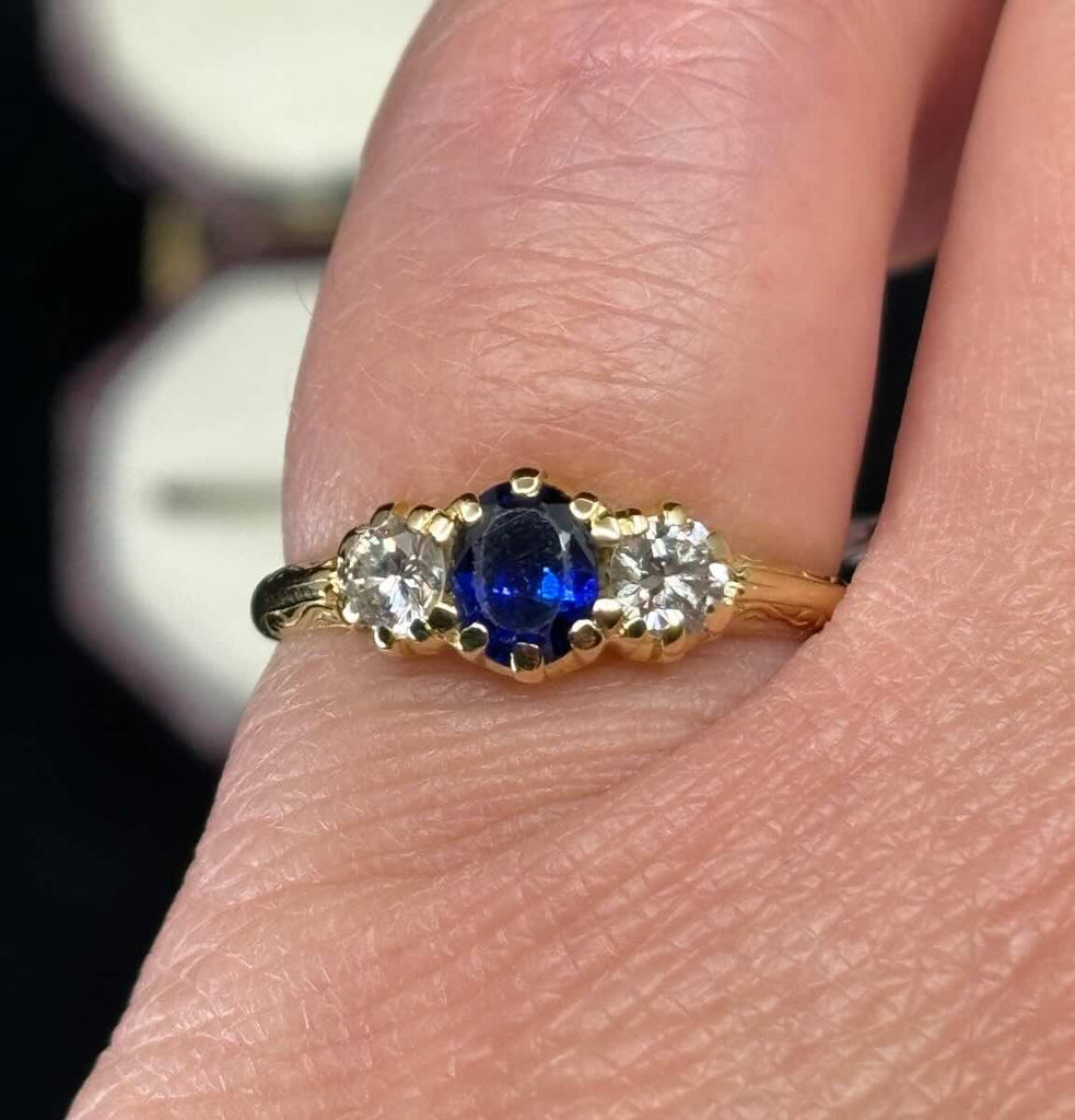 Close‑up of a 1950s oval sapphire engagement ring showing vivid royal blue centre stone and sparkling round brilliant diamonds on a 2mm 18ct yellow gold band.