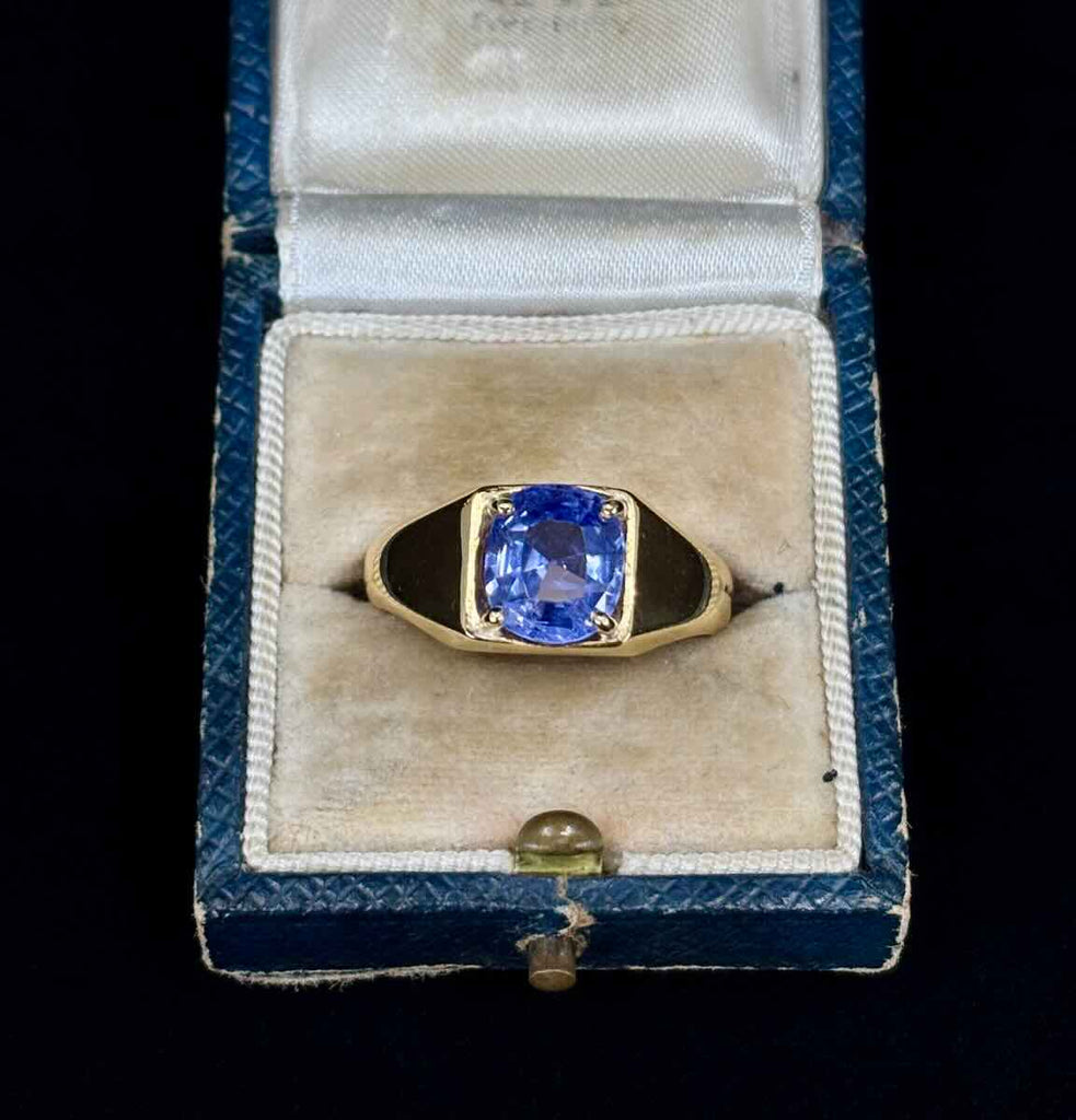 Vintage 1970s gold signet ring with a blue sapphire in a ring box.