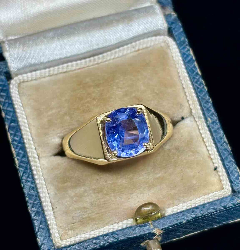 1970s men's ring showcasing a sapphire in a gold signet ring setting.