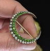 Victorian gold crescent moon brooch held in hand, showing vivid green demantoid garnets, natural pearls and pin fitting
