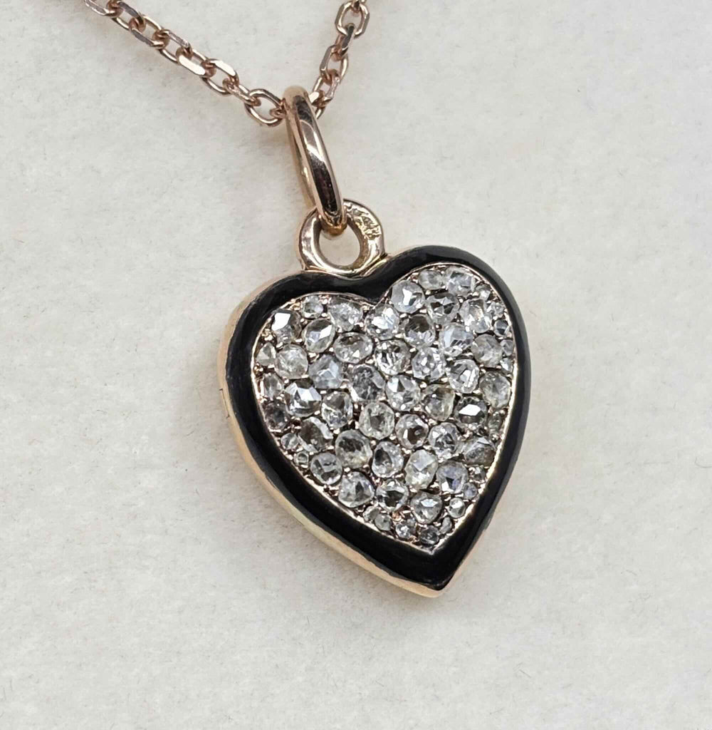 Angled front view of the Victorian rose gold heart locket showing pavé-set rose-cut diamonds framed by black enamel
