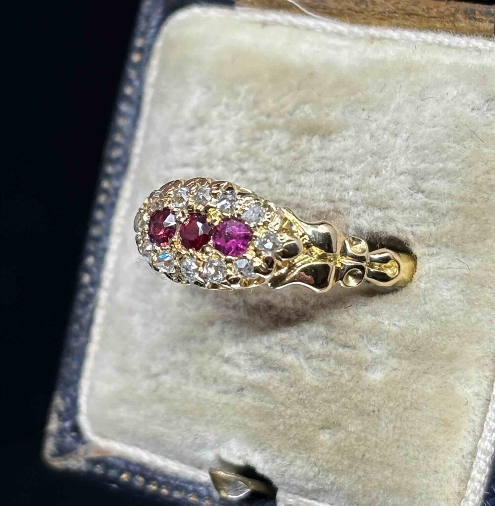 Side view of the antique Edwardian ruby diamond ring showing its raised cluster setting and carved 18ct gold shoulder