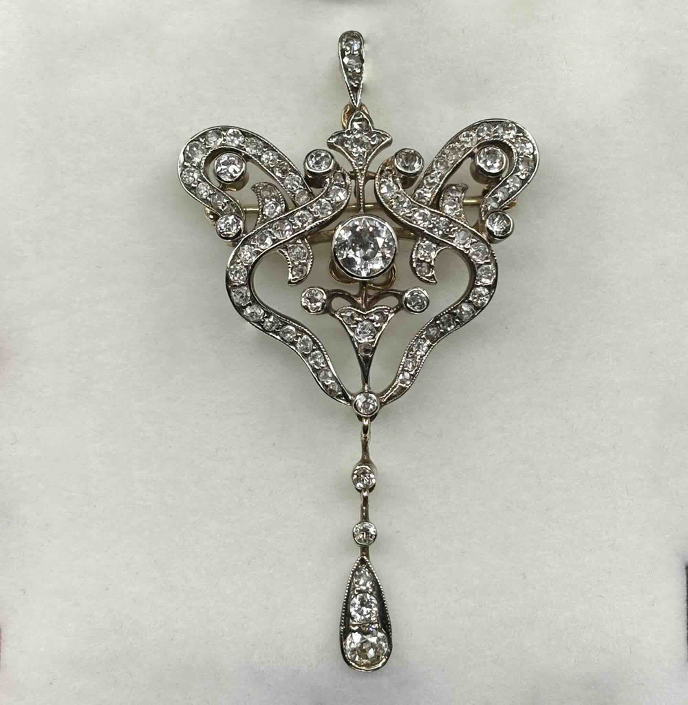 Close-up of the antique Victorian diamond pendant brooch showing openwork scrolls, mixed-cut diamonds and pendant fitting
