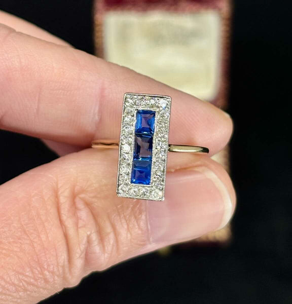 Detailed image of a 1930s sapphire and diamond ring, highlighting the rectangular cluster and two-tone metal.