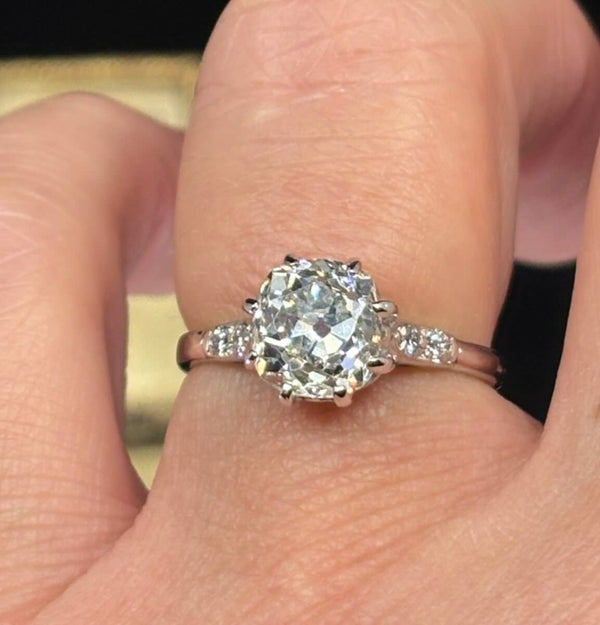A antique 1920s 2.45ct old mine cut diamond ring set in 18ct white gold shown on the finger.