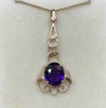 front on view of the oval purple amethyst surrounded by a delicate handmade rose gold frame against a cream background