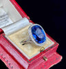 A platinum sapphire and diamond cluster ring showcasing an estimated 10.48ct sapphire with a history dating back to 1910.