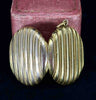 Dual view of the antique Victorian gold oval locket with intricate striped design.