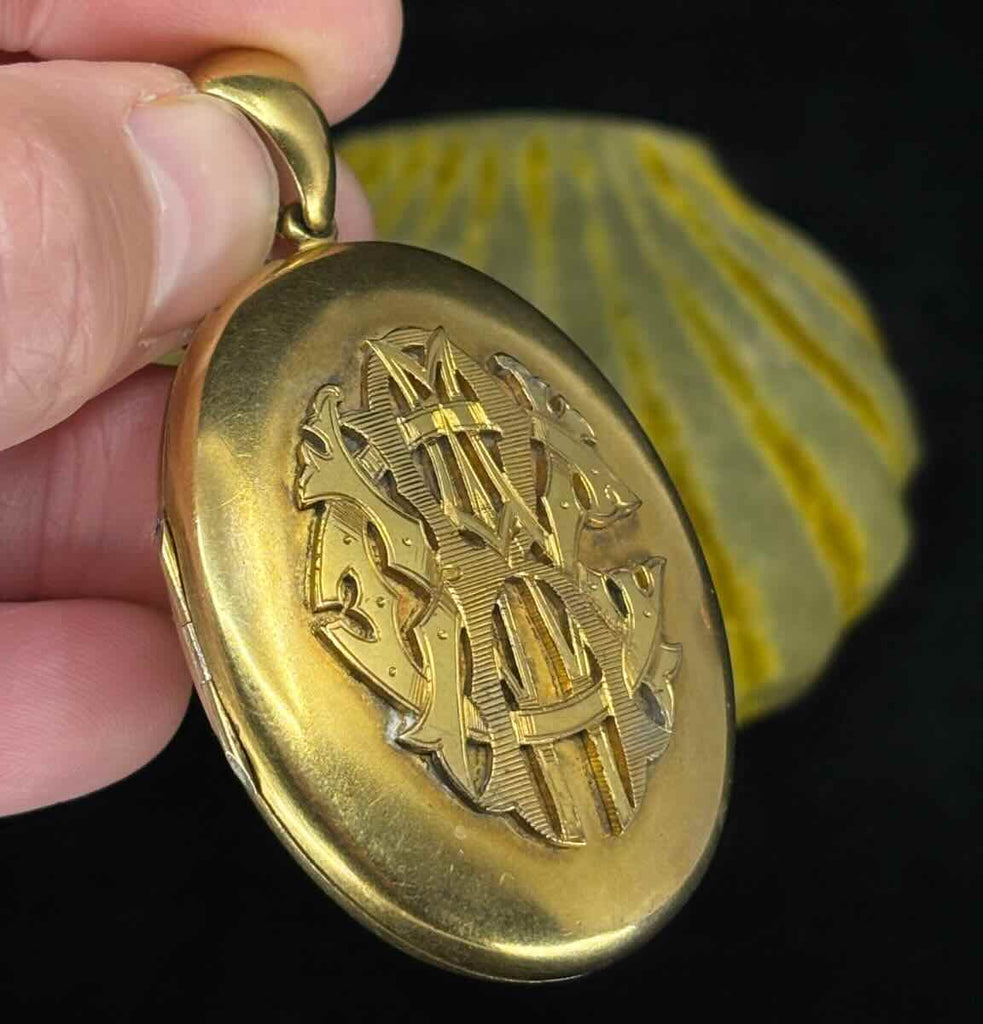 A side view of the antique gold locket featured the front monogram