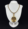 The large antique gold oval locket features on a bust on an antique Victorian gold collar