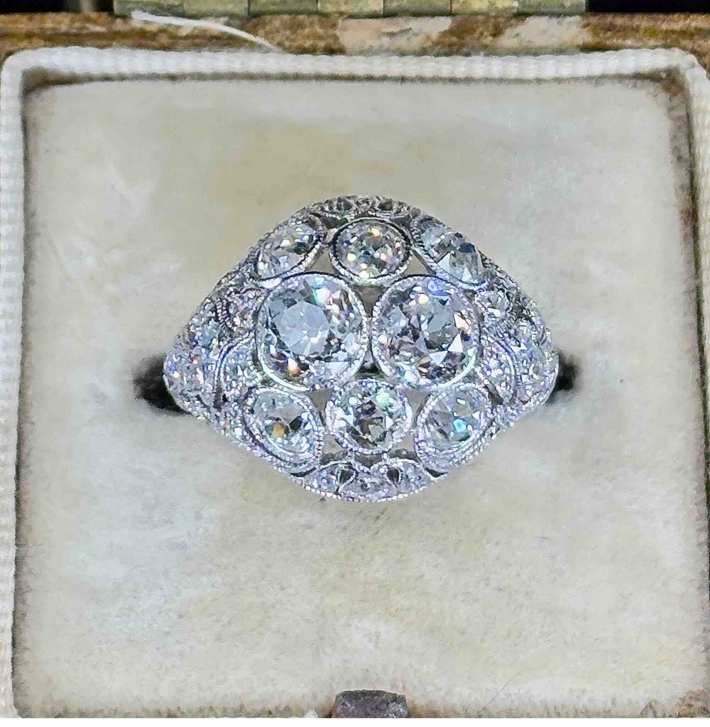 art deco platinum diamond ring featured front on in an antique cream ring box