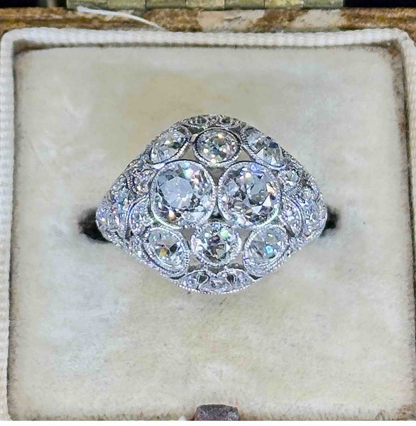 art deco platinum diamond ring featured front on in an antique cream ring box