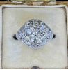 art deco platinum diamond ring featured front on in an antique cream ring box