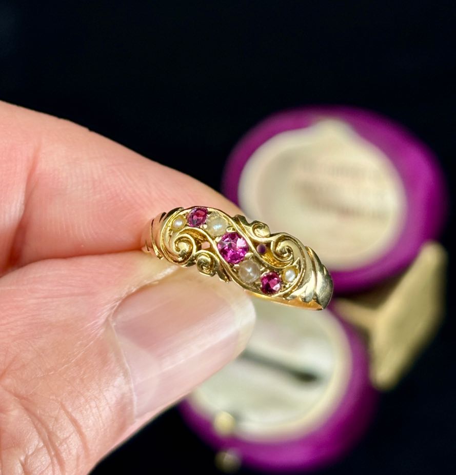 An elegant Australian ring from 1894, designed by Lamborn & Wagner, featuring ornate scrollwork and colourful gems.