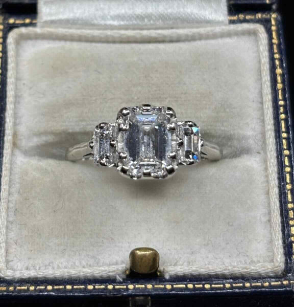 E colour VS2 emerald cut diamond in ten-claw platinum setting with baguette diamonds — elegant engagement ring