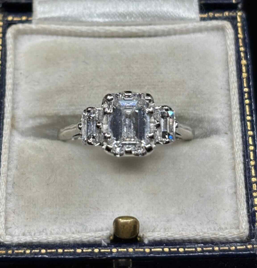 E colour VS2 emerald cut diamond in ten-claw platinum setting with baguette diamonds — elegant engagement ring
