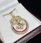 Elegant Victorian diamond pendant adorned with rubies and an intricate eternity knot design.