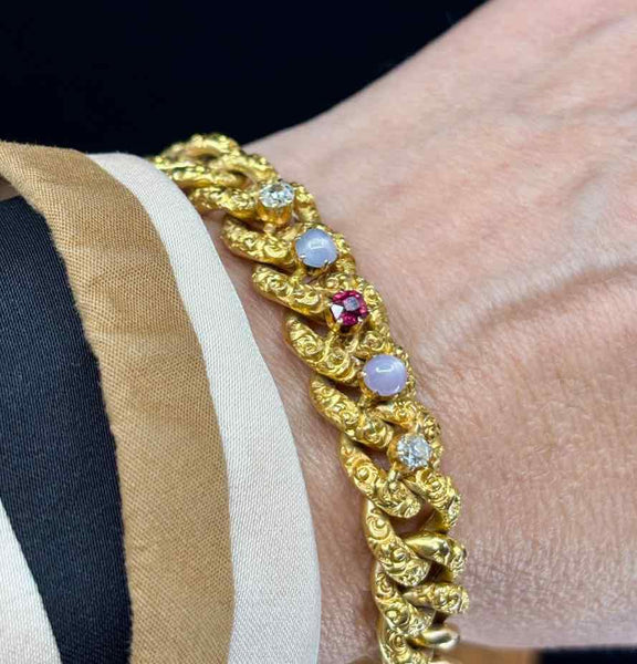 Elegant Victorian gold curb link bracelet accented with diamonds and star sapphire.