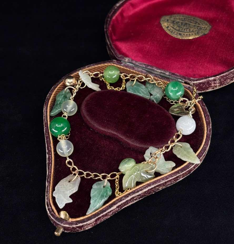 Exquisite jade padlock bracelet from the 1960s made of yellow gold, showcasing intricate jade carvings.