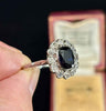French Art Deco ring with a blue sapphire gemstone, made in platinum and held by a hand against a dark background