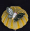 Detailed view of a gemstone butterfly brooch with intricately carved nephrite wings and cabochon cut ruby eyes.