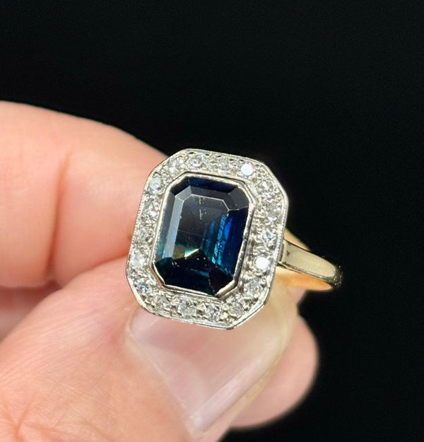 One-of-a-kind 1930s emerald cut sapphire statement ring adorned with early single cut diamonds.