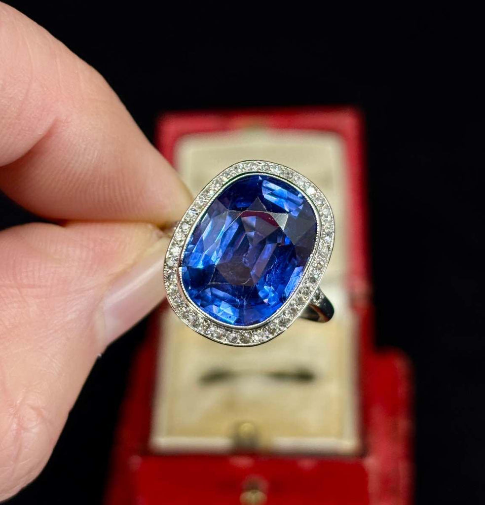An Edwardian sapphire and diamond cushion cluster ring featuring a 10.48ct Ceylon sapphire set in platinum, surrounded by 38 old single cut diamonds.