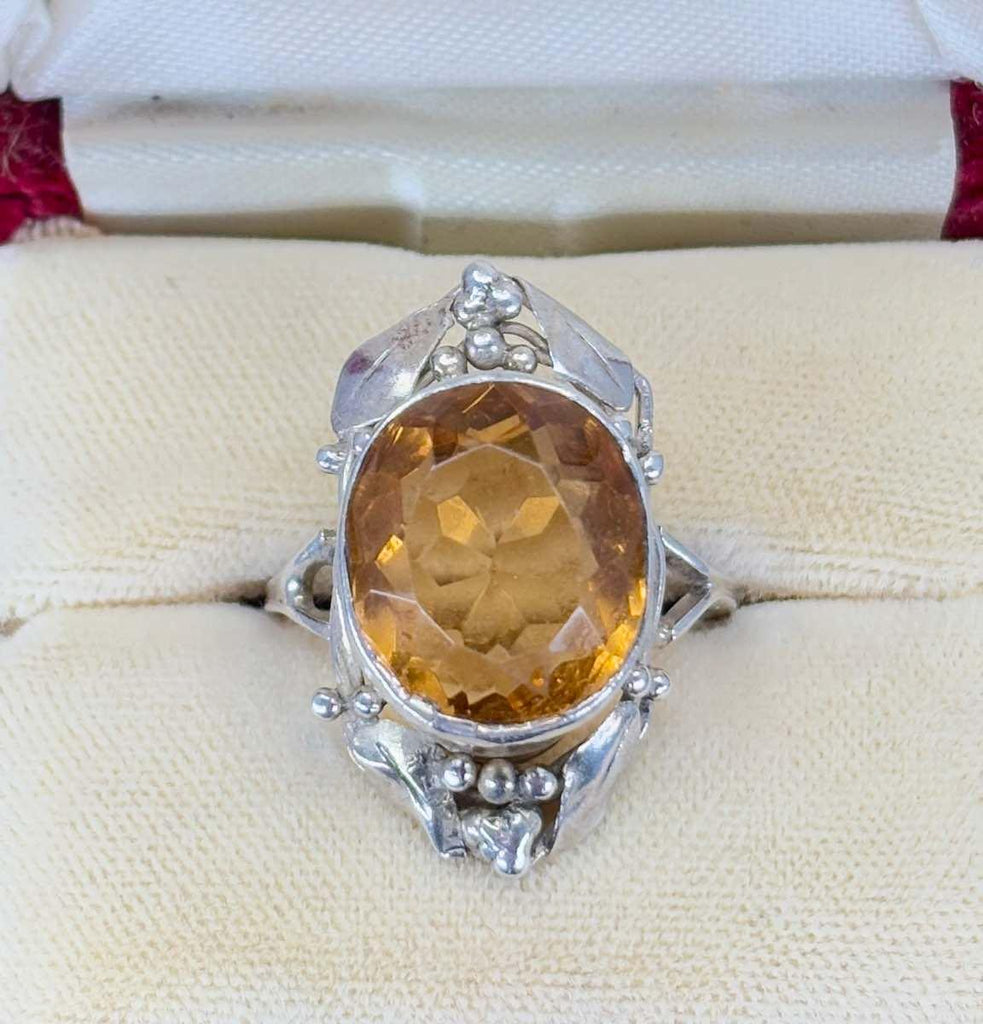 A close up photo of the Rhoda Wager citrine and gumleaf surround, with fine shoulders to a fine silver band