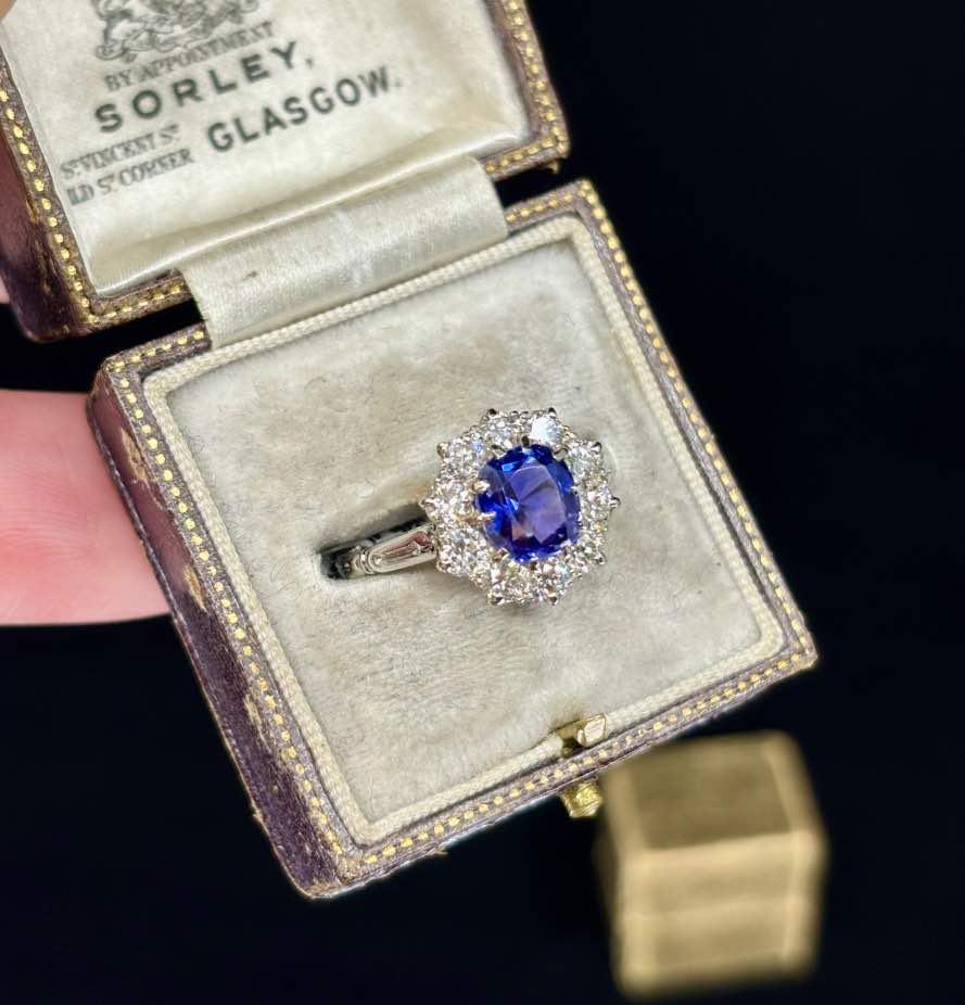 Unique 1930s jewelry piece featuring a purplish-blue Ceylon sapphire and diamond halo.