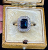 Unique engagement ring from the 1930s with an emerald cut sapphire and diamond accents.