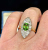 Close-up of a stunning Victorian marquise cluster ring featuring an oval peridot surrounded by old cut diamonds, set in 15ct yellow gold.