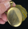 The shiny surface and patina of the 18ct yellow gold back of the Victorian locket