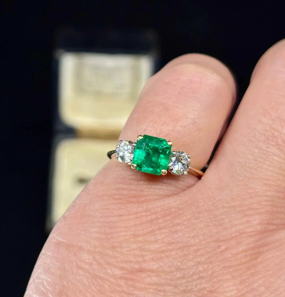 Vintage 1950s emerald cut emerald ring with diamond accents set in 18ct yellow gold.