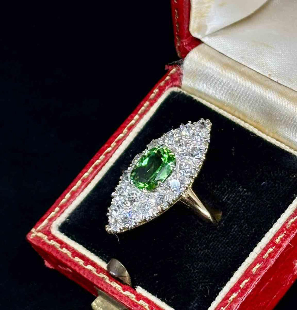 Detailed view of a vintage Victorian peridot ring adorned with diamonds, highlighting the intricate setting and elegant design.