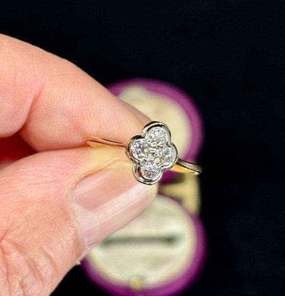 A stunning vintage quatrefoil diamond ring displayed in a plush purple velvet box. Perfect for antique jewelry enthusiasts.