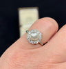 Antique 1920s Hardy Brothers platinum ring with silvery near‑round natural pearl and diamond petal cluster.