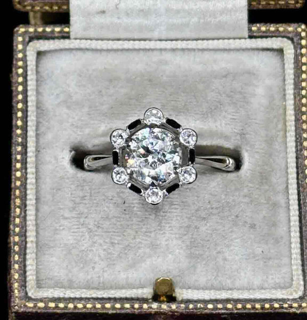 Antique diamond ring featuring a black enamel border and cluster design.