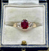 Antique Edwardian 1905 three‑stone ring with 2.53ct oval ruby and two old‑European cut diamonds (0.46ct) in 9ct yellow gold — claw set, vintage engagement ring.