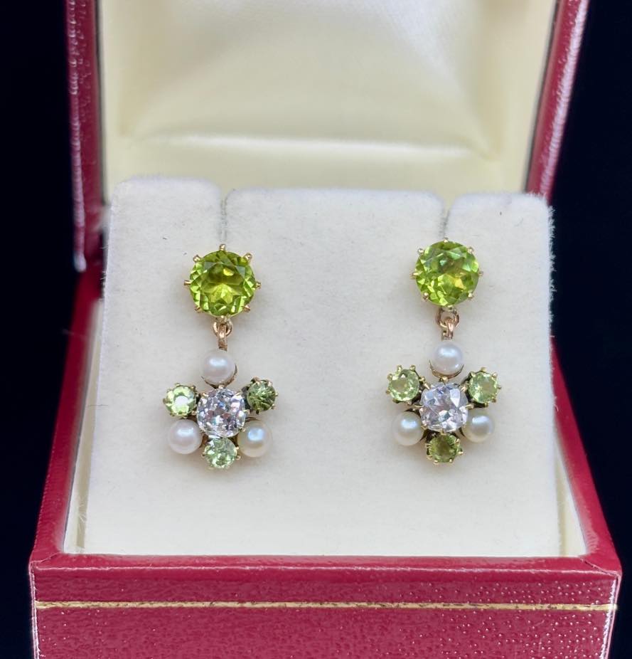 Antique Edwardian earrings featuring a cluster of peridot, diamond, and pearl set in 15ct yellow gold, showcasing vintage elegance from the early 20th century.