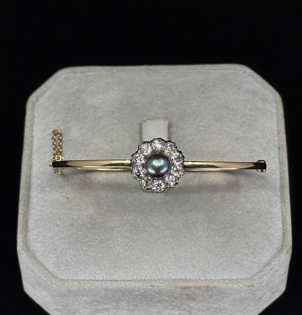 An antique natural black pearl and diamond flower cluster bangle set in 18ct yellow gold, made in 1880 by Austro Hungarian jewellery designer Anton Deutch