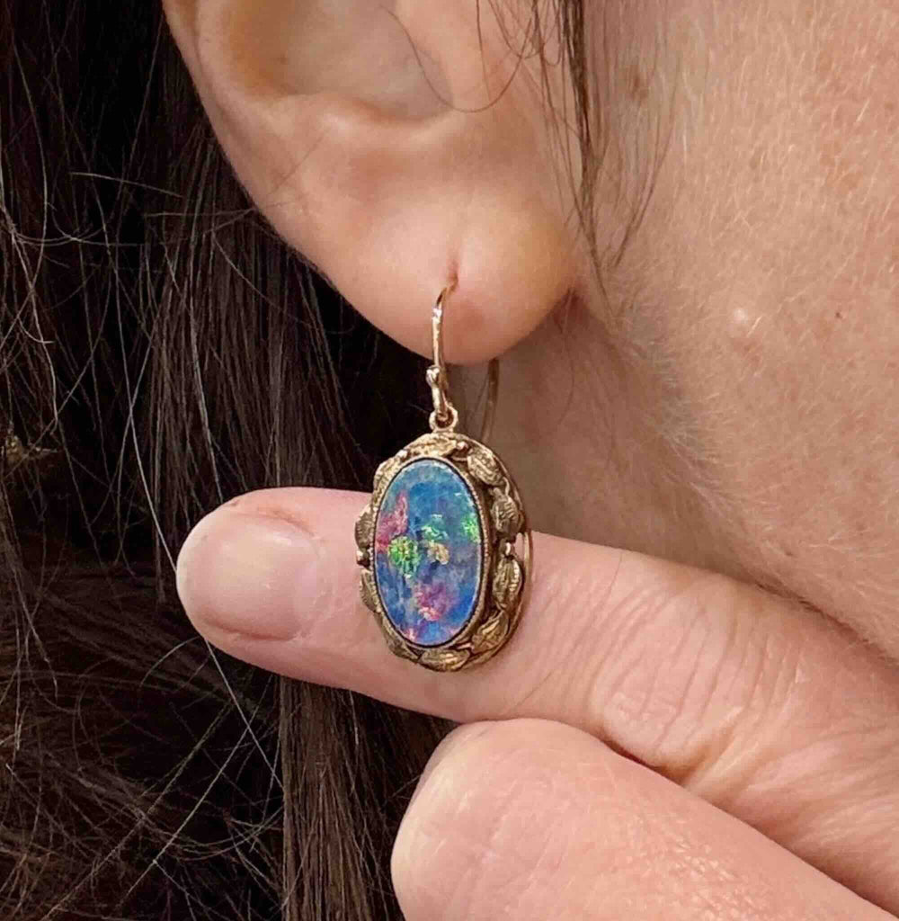 Antique opal doublet earring held against a finger showing size and colour detail