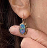 Antique opal doublet earring held against a finger showing size and colour detail